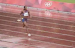 Photo of Dalilah Muhammed while running on a red athletics track