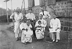 A Native Filipina with Caucasians (probably Europeans or Americans), Chinese, and Japanese settlers in the Philippines, c. 1900
