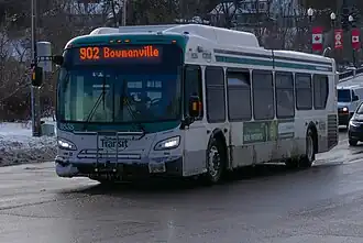 A baseball game being played on a green field viewed from behind home plate