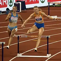 Photo of Viivi Lehikoinen between hurdles and Femke Bol jumping over a hurdle