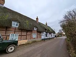 Thatched cottages in the village of Ecchinswell, Hampshire, England. December 2024.