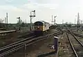 A class 56 heads a northbound aggregates train through Ely station. Note the semaphore signals which were removed during the electrification and resignalling scheme.