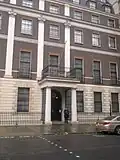 A policeman outside the embassy; the National Emblem of the People's Republic of China can be seen above the door
