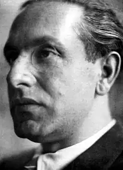 A black and white photo of Julius Evola, looking left. He wears a monocle
