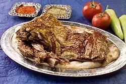 Bakır tabakta servis edilmiş bir fırın kebabı porsiyonu.