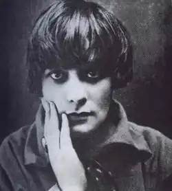 Black and white portrait photograph of a young woman with short dark hair wearing a dark dress