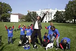 First Lady Michelle Obama and students on White House lawn with puppies
