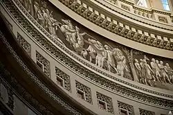The Frieze of American History in the Rotunda of the United States Capitol contains a painted panorama depicting significant events in American history. The frieze’s 19 scenes is the work of three artists: Constantino Brumidi, Filippo Constaggini and Allyn Cox. The frieze is painted in grisaille, a monochrome of whites and browns that resembles sculpture. It measures 8 feet 4 inches in height and approximately 300 feet in circumference. It starts 58 feet above the floor.