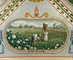 A couple picks cotton in the south with their cabin behind them and the plantation house in the distance.