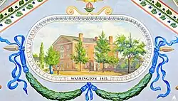 A brick multi-story building surrounded by trees. Below the building are green garlands, and directly below is the text "WASHINGTON, 1815".