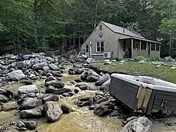A hot tub and a sedan sit on rocks damaged as a result of the floods in Vermont in July 2023.