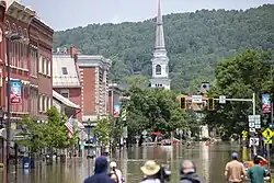 An image shows street flooding in downtown Montpelier, which is the county seat of Washington County and the capital city of Vermont. Taken from a ground view.