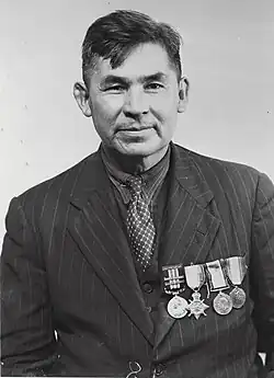 older man with suit, tie, and medals on his chest