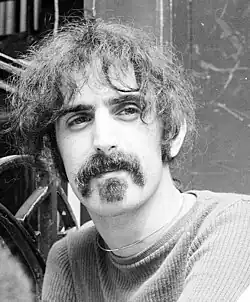 A black and white head shot of Frank Zappa