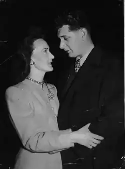 Selwyn David Evans (right) conversing with Gail Adams, who is clutching him, in a dark environment