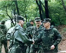 General Frederick M. Franks Jr., Commander of United States Army Training and Doctrine Command tours Camp Jackson. Pictured shaking hands with NCO Academy trainee Corporal Daniel L. Dow, at 2nd Infantry Division (United States) (South Korea) NCO Academy on 31 May 1993.