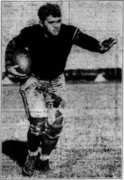 A black and white photograph of an American football player from the 1920s