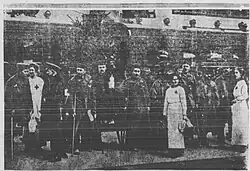 B&W photo of men in uniform standing around