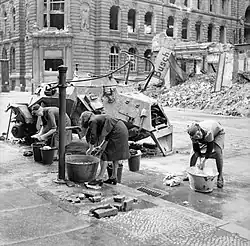 Women doing their wash at a cold water hydrant in a Berlin street, July 1945