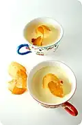 A honey tuile over cups containing a sweetened cream, ginger panna cotta.