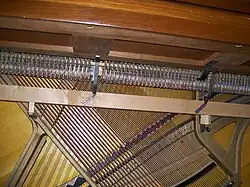 Detail of the interior structure of the Gulbransen spinet shown above. The drop action, lying below the level of the keyboard, can be seen, as well as the extreme angling of the strings needed to provide sufficient length of strings within the limited case height. Click on image for expanded view.