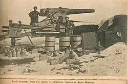 soldier standing in front of a 15 cm caliber gun