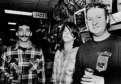 Three men standing and holding drink cans