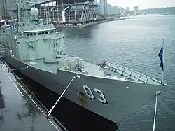 Photograph of a frigate's bow and the front of her superstructure. Two weapons systems can be seen on the forward deck.