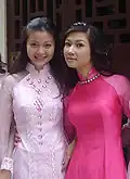Two woman wearing pink Áo dài
