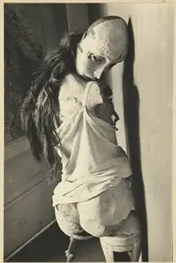 Black and white art photograph of a doll, posed suggestively