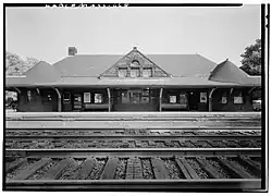 View of a Romanesque-style railroad station from across the tracks