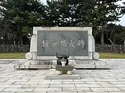 A rectangular stone monument with "抗蒙殉義碑" inscribed in the middle in large characters