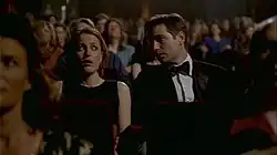 A man and a woman stare in horror during a movie showing.