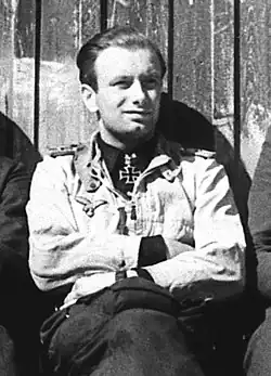 A man wearing a military uniform sitting.
