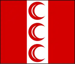 Alternating red and white vertical stripes. The white stripe contains three red crescents, horns facing right.