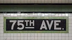 White and green tile mosaic spelling out the station name