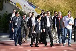 Several people walk on a running track.