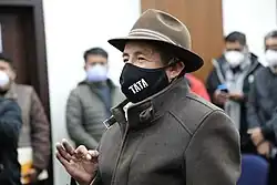 Quispe makes the sign of the cross with his hand.