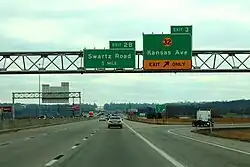 A freeway exit with an overhead sign reading Exit 3 - K-32, Kansas Avenue.