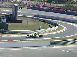 Photograph of Wilson driving his Jaguar into the pit