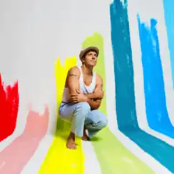 The cover features Jason Mraz squatting down barefooted, wearing a white hat and tank top, and light blue jeans. Behind him is a grey wall, with color strips of red, pink, yellow, lime green, turquoise, sky blue and light blue respectively.