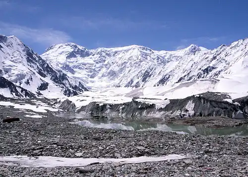 Tall snow-covered mountains with a small lake in front