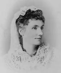 Black and white image of dark-haired woman with white veil over the back of her head