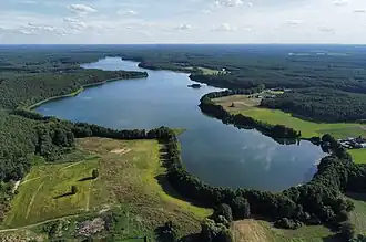 Green fields on the sides and a body of water in the middle under a clear sky.