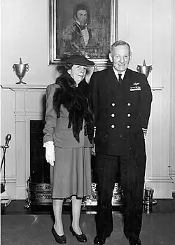 Black and white photograph of a man and woman in front of a fireplace