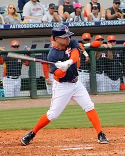 Jose Altuve, in Houston's navy spring training uniform, swings at a pitch