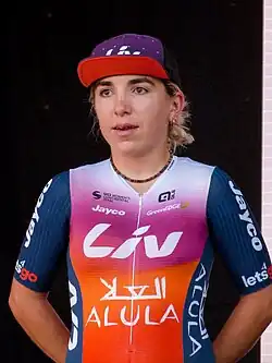 Kaia Schmid, wearing a cap and cycling jersey that reads "Liv Alula" across the torso.