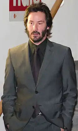 A candid portrait of Keanu Reeves wearing a gray suit.