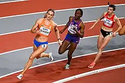 Photo of Lieke Klaver, Talitha Diggs, and Susanne Gogl-Walli running in the bend of a red 200-metres track