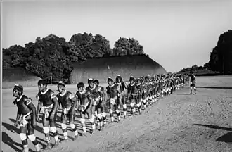 A line of several Indigenous men at a traditional cerimony